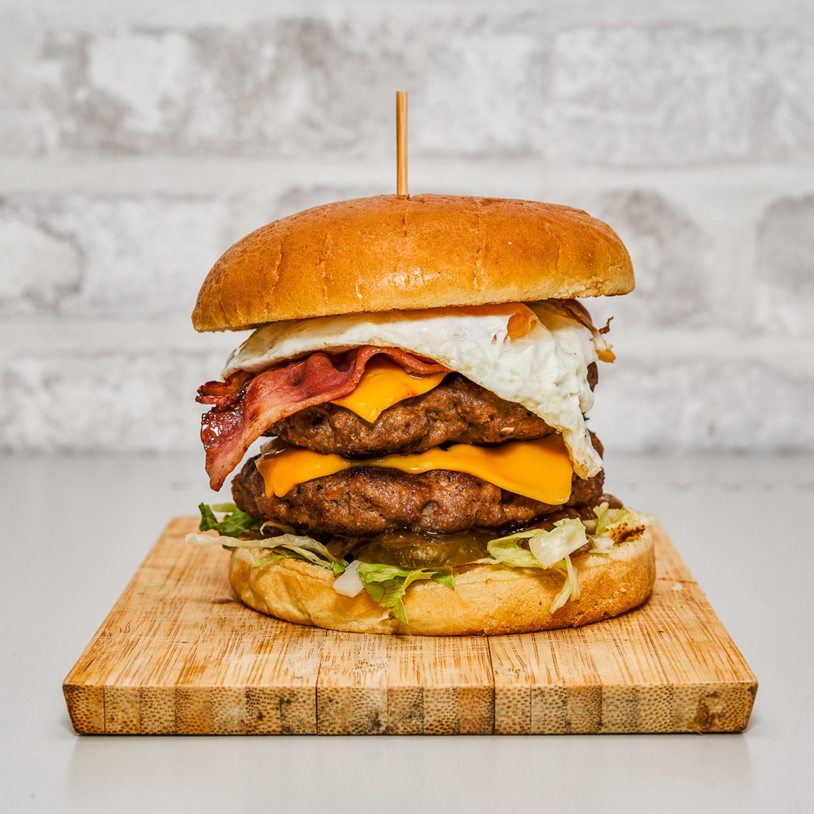 Hamburguesa presentada sobre una tabla de madera