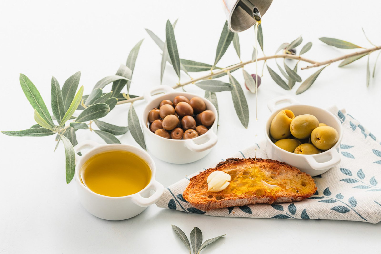 Bodegón gastronómico de aceite de oliva, aceitunas y pan